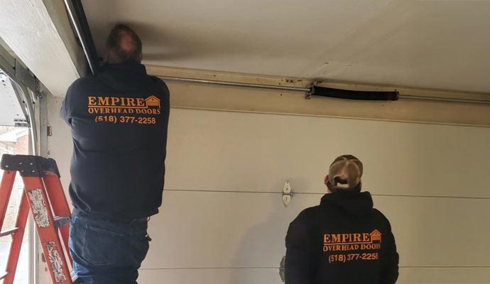 Couple of technician repairing garage door Couple of technician repairing garage door